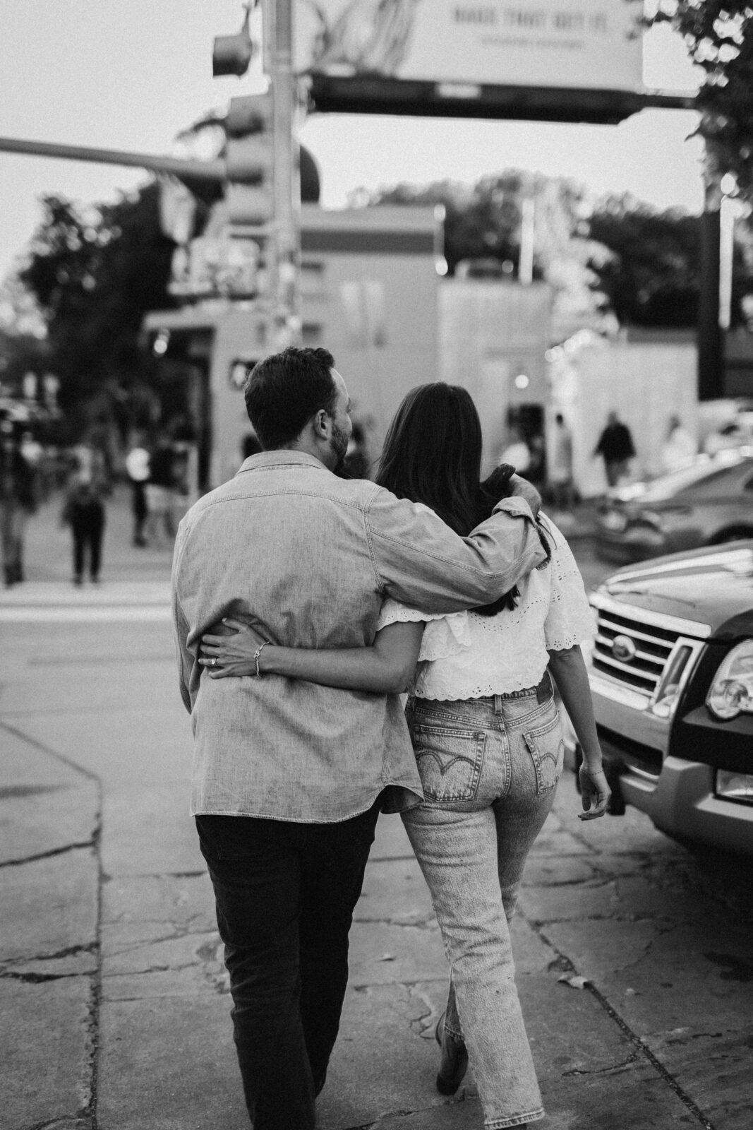 Couple walking holding each other in black and white